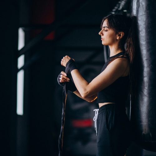 Young woman boxer training at the gym